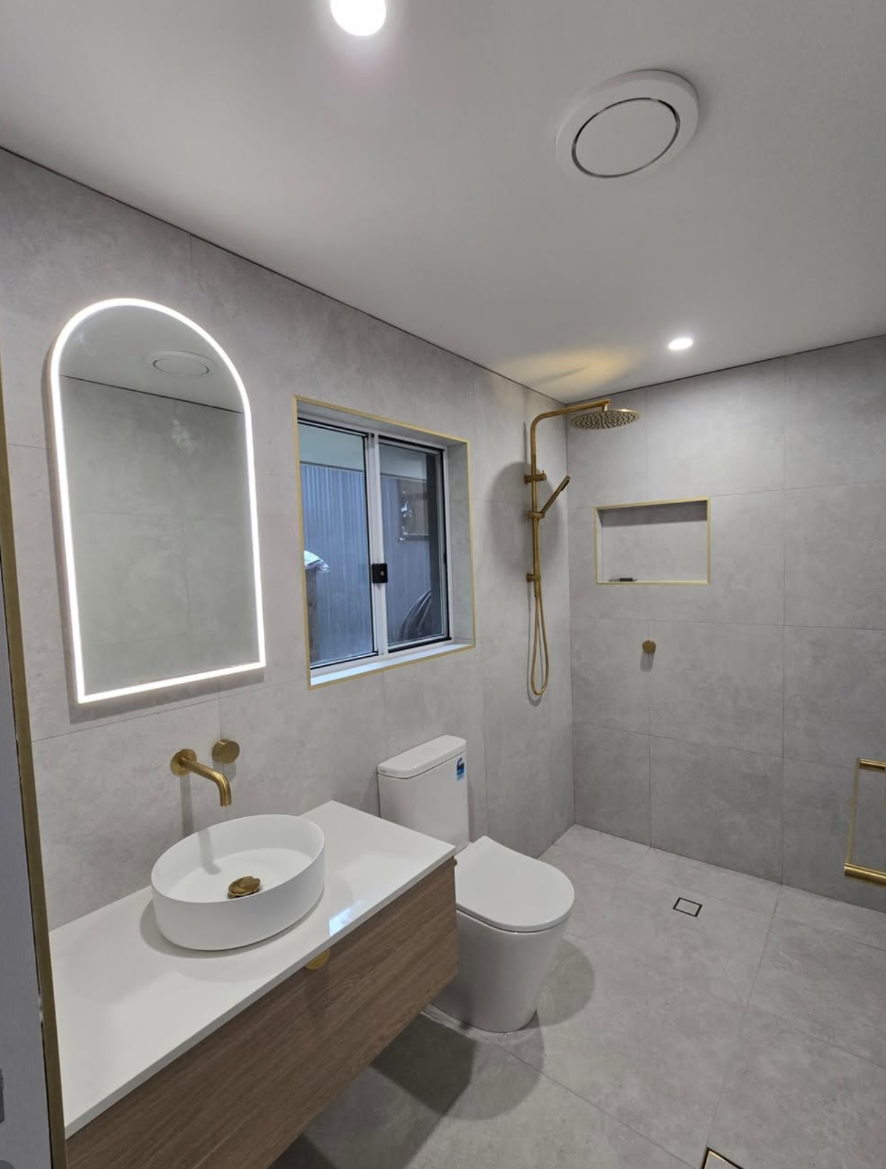 Arched LED mirror, brass tapware and vessel sink — Noosa ensuite renovation