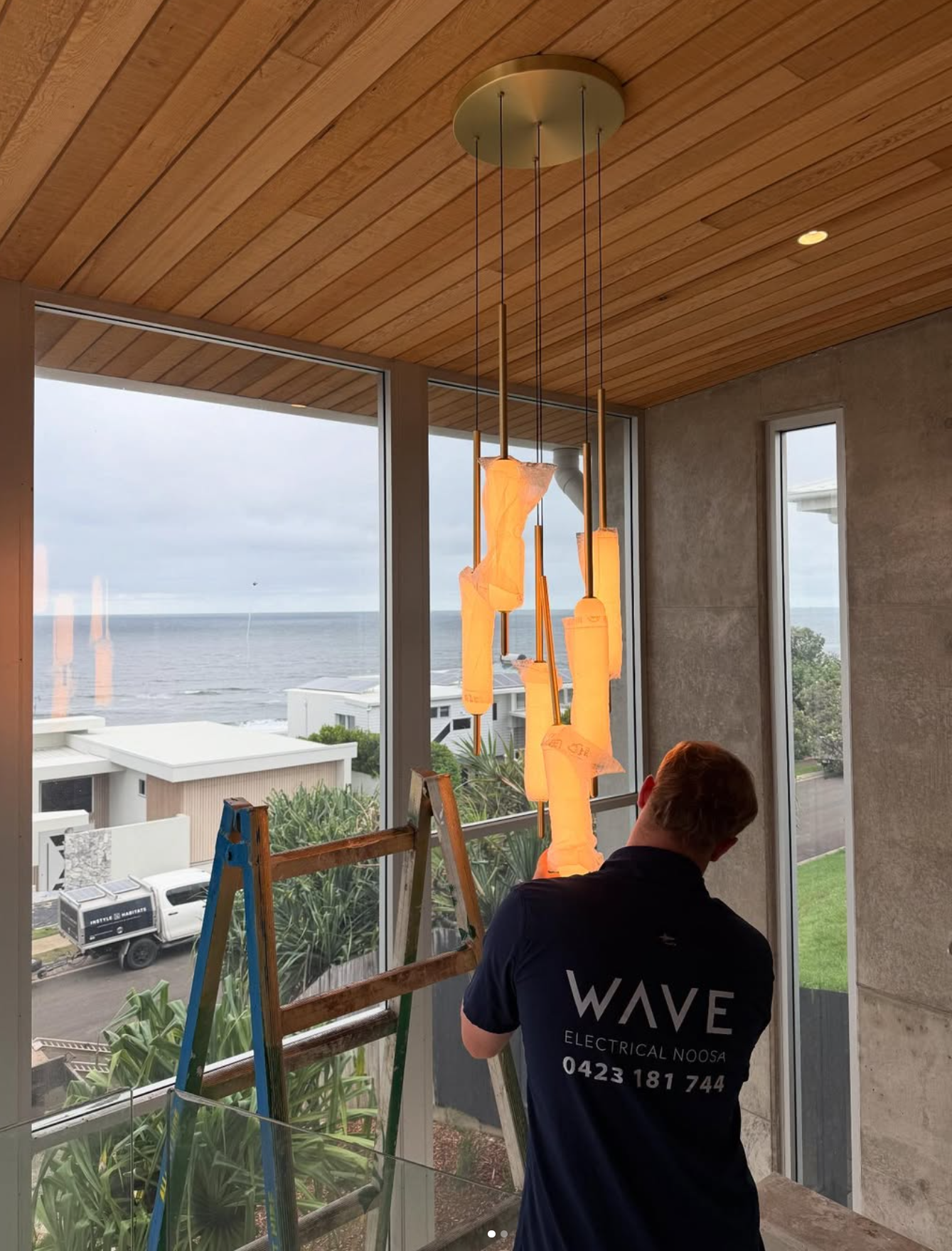 Wave Electrical technician installing pendant lights — oceanfront home