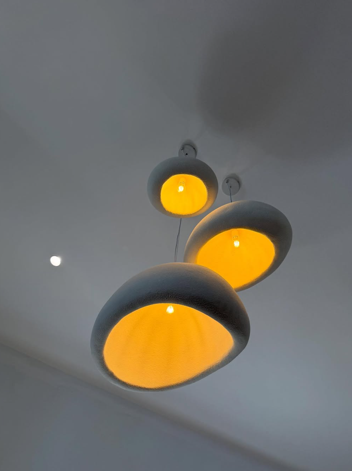 Three organic egg-shaped pendant lights glowing orange — pendant installation Noosa