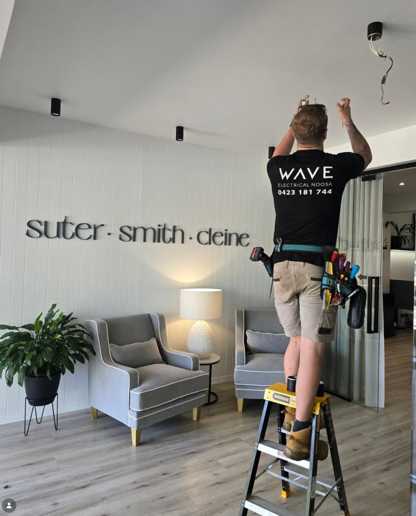Wave Electrical technician installing track lighting at Suter Smith Deine real estate office — Noosa