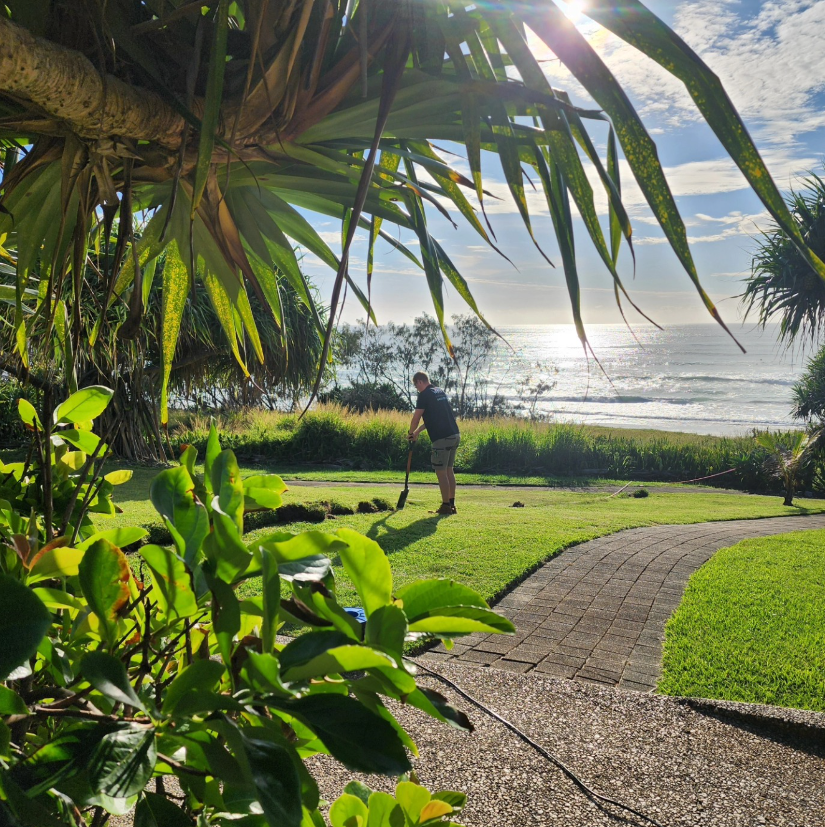 Wave Electrical technician trenching at an oceanfront property — underground cable Noosa beachfront