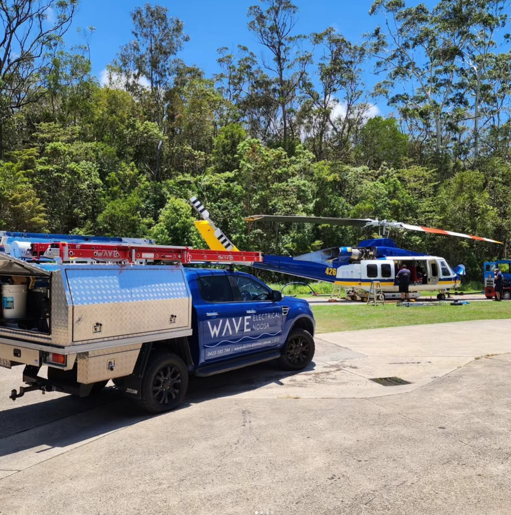 Wave Electrical ute parked next to a helicopter on a job